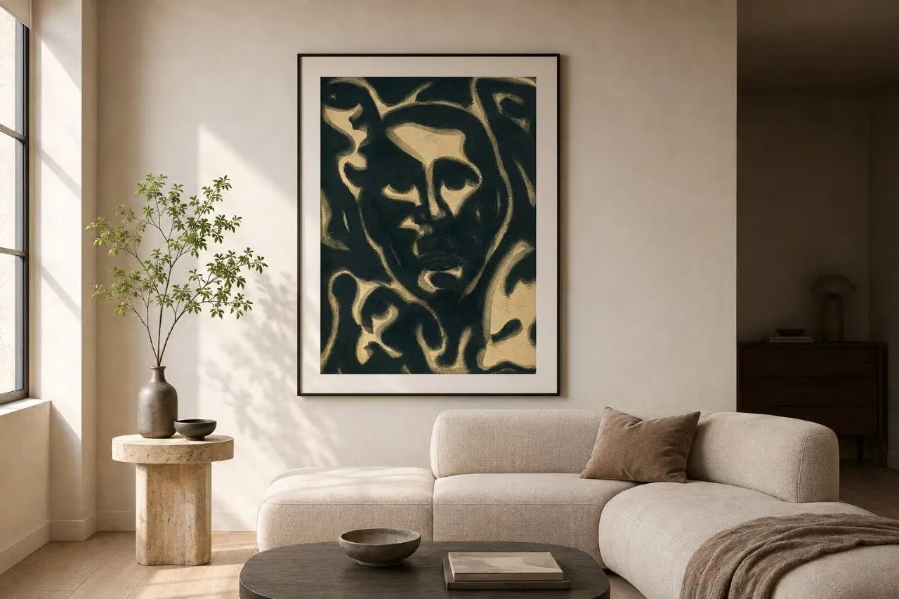 A dark ROCHAN painting in gold and deep blue-black, a face emerging from interlocking organic shapes, framed on a warm plaster wall above a pale sofa.